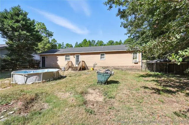 a view of a house with backyard and a tree
