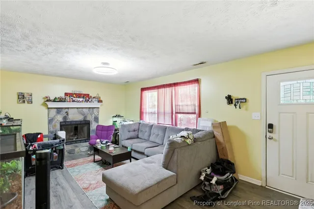 a living room with furniture a fireplace and window