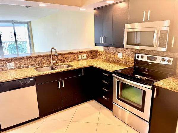 a kitchen with a sink stove and microwave