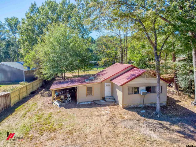 a yellow and red house with a large tree
