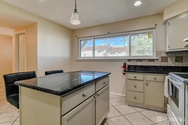 a kitchen with stainless steel appliances granite countertop a sink a stove and a refrigerator