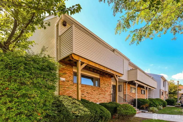 a front view of a house with a tree
