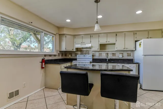 a kitchen with kitchen island granite countertop appliances cabinets and a counter top space