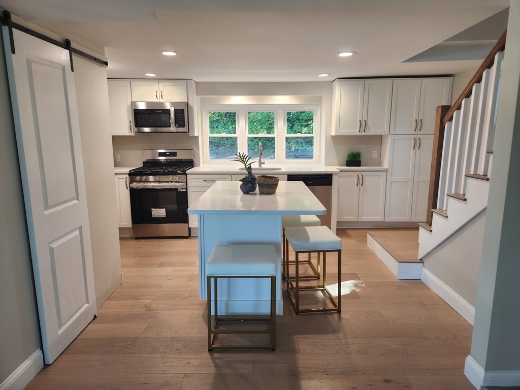 41 Pecksuot Road Weymouth, MA 02191 - Photo 11 of 22 a kitchen with stainless steel appliances granite countertop a refrigerator a stove top oven and a sink with granite countertops