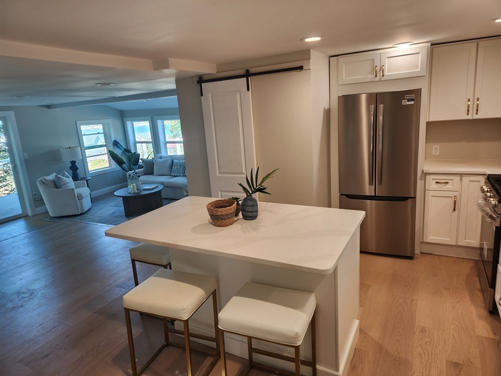 41 Pecksuot Road Weymouth, MA 02191 - Photo 10 of 22 a kitchen with stainless steel appliances a dining table chairs and wooden floor