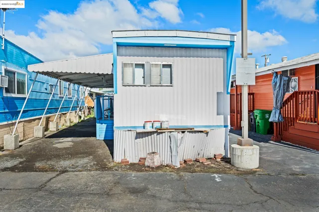 a view of a small house with wooden fence