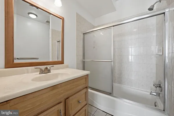 a bathroom with a bathtub shower sink and mirror