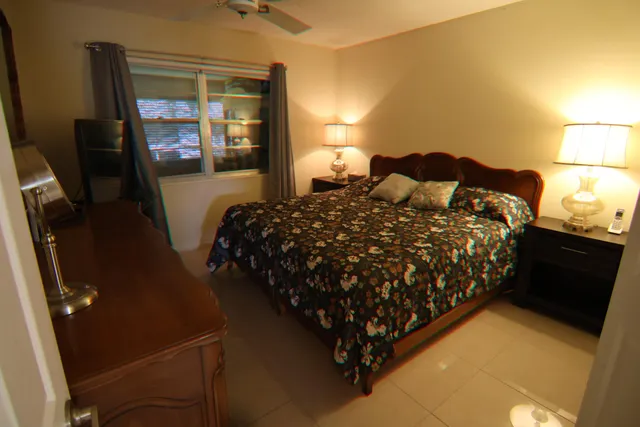 a bed sitting in a bedroom next to a lamp