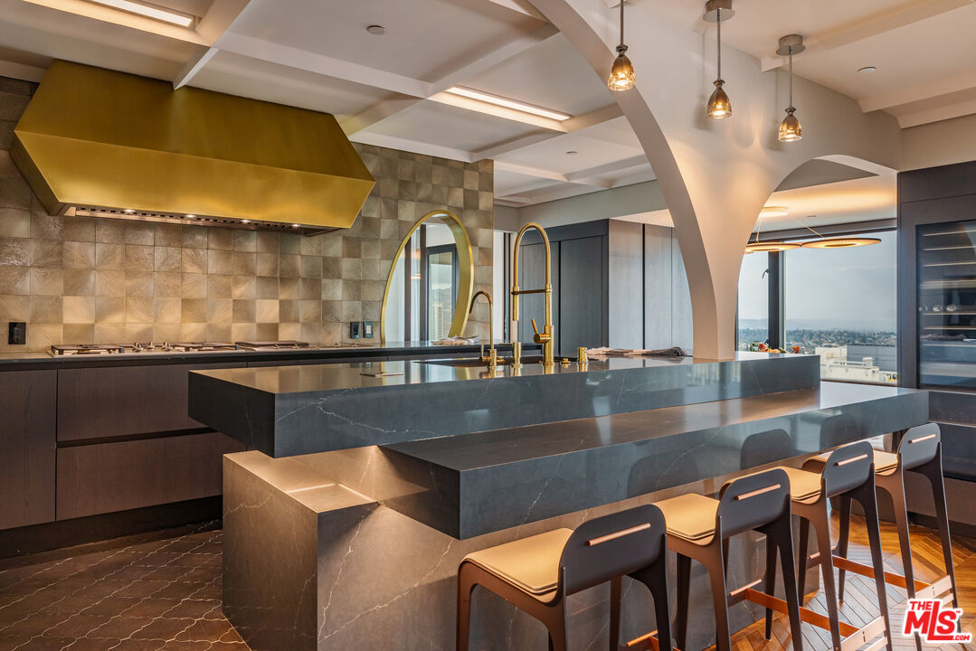 10727 Wilshire Boulevard, Unit 1805 Los Angeles, CA 90024 - Photo 15 of 34 a kitchen with a table chairs and a wooden floor