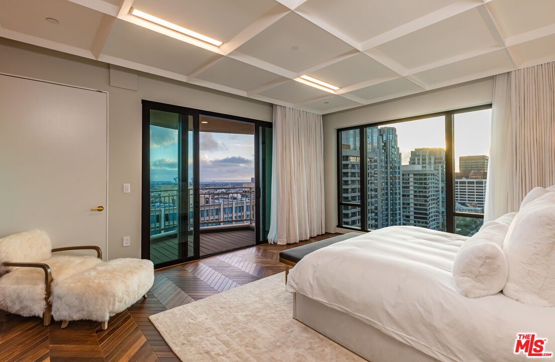 10727 Wilshire Boulevard, Unit 1805 Los Angeles, CA 90024 - Photo 20 of 34 a spacious bedroom with a bed and glass walk in closet