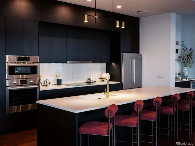 a kitchen with granite countertop a sink cabinets and stainless steel appliances
