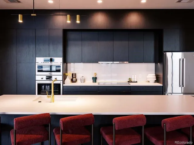 a kitchen with a dining table chairs cabinets and stainless steel appliances