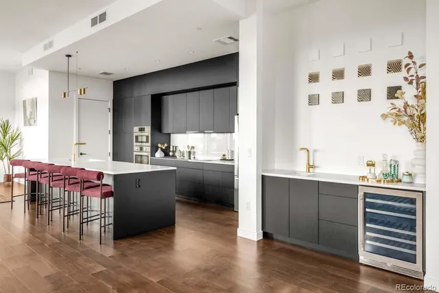 a kitchen with kitchen island a sink cabinets and wooden floor