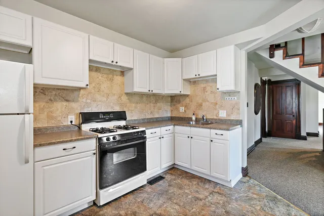 a kitchen with granite countertop white cabinets stainless steel appliances and sink