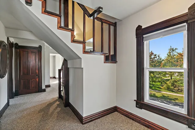 a view of a hallway with entryway and hall with wooden floor
