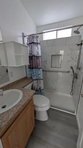 a kitchen with stainless steel appliances granite countertop a sink a stove and a wooden floors