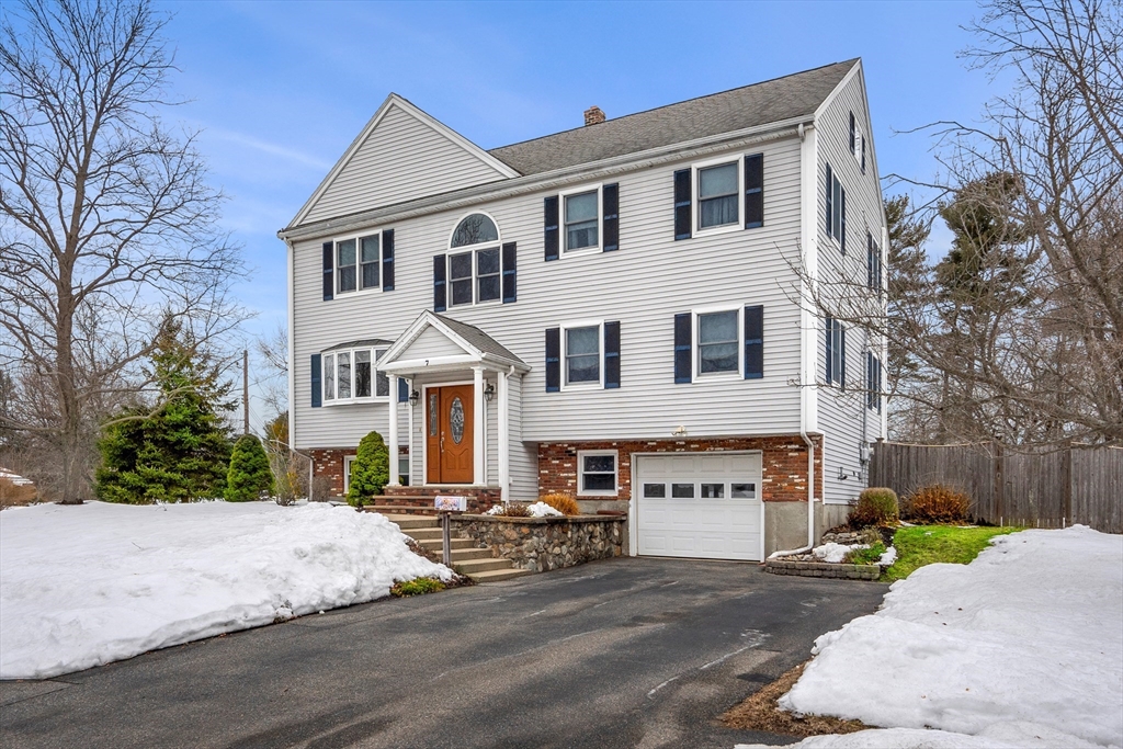 a view of a white house with a yard and large tree