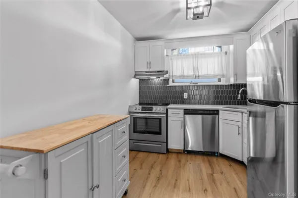 a kitchen with stainless steel appliances granite countertop a stove a sink and a refrigerator