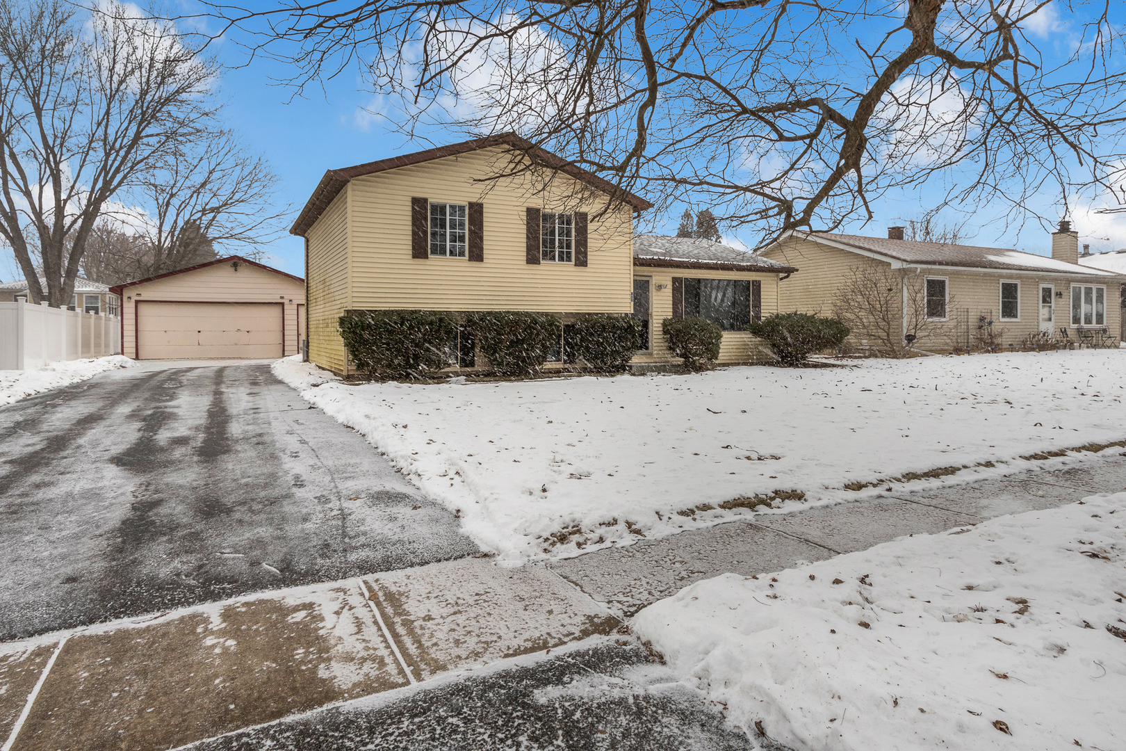 a front view of a house with a yard covered with snow in front of house