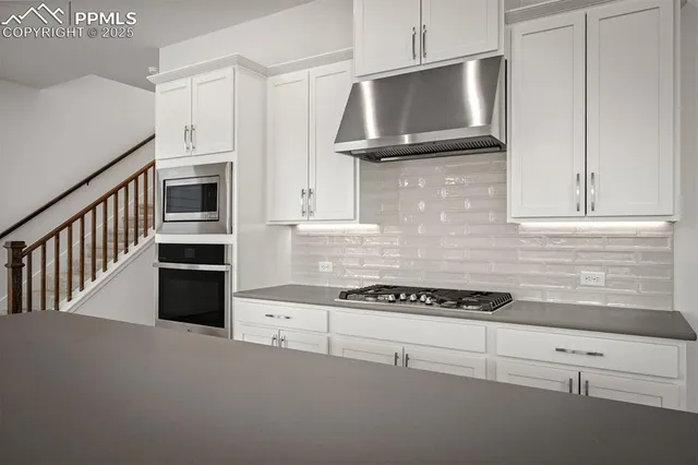 a kitchen with granite countertop cabinets and steel stainless steel appliances