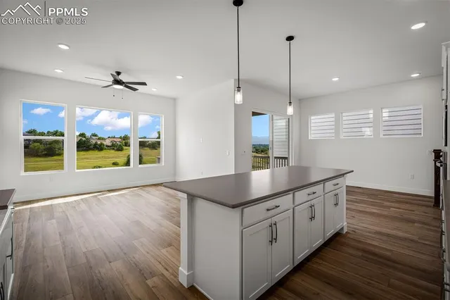 a kitchen with stainless steel appliances granite countertop a sink a wooden floor and a large window