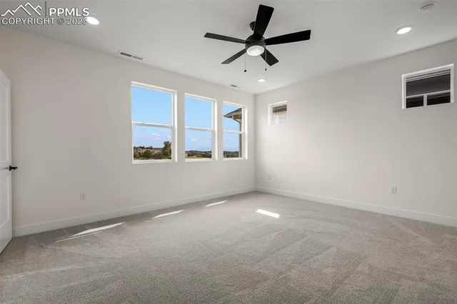 en empty room with windows and ceiling fan