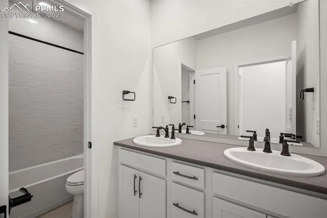 a bathroom with a double vanity sink toilet and a mirror