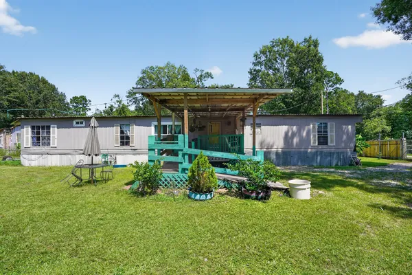 a view of house with backyard and furniture