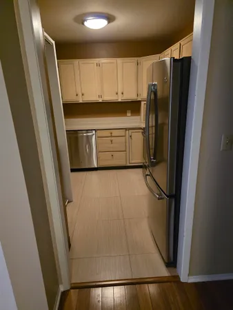 a kitchen with a refrigerator a sink and cabinets