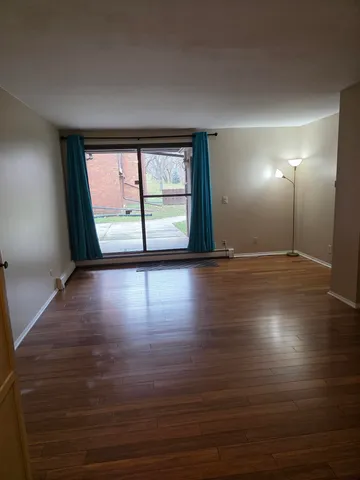 a view of room with window and wooden floor