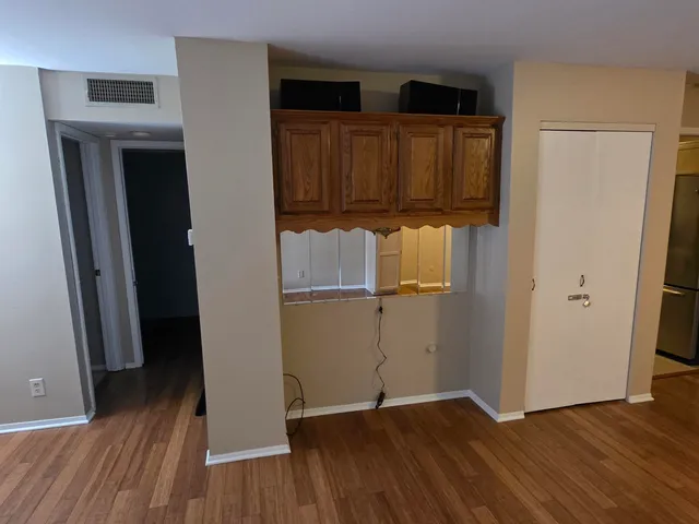 an empty room with wooden floor and closet
