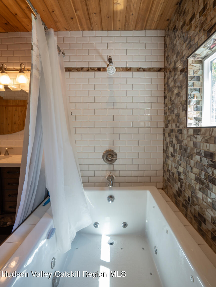 16 Robin Road, Unit GO UP ROBIN ROAD NOT DOWN Copake, NY 12521 - Photo 28 of 32 a bathroom with a sink a mirror and shower