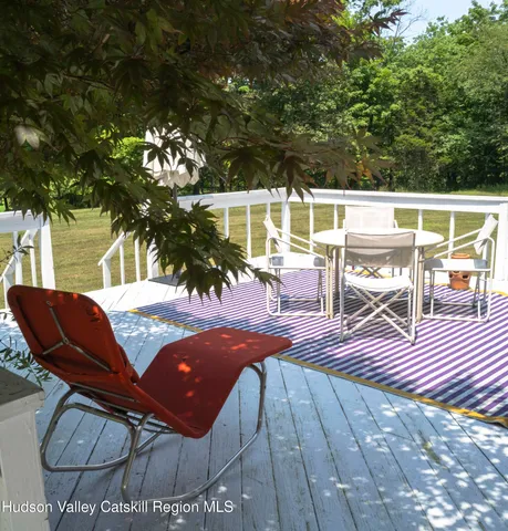 a view of a patio with table and chairs with wooden floor and fence
