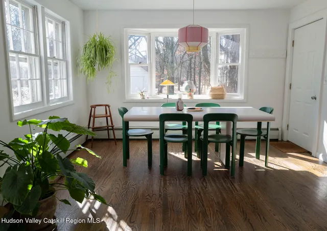a dining room with furniture potted plants and wooden floor