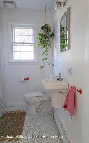 a bathroom with a sink toilet and window