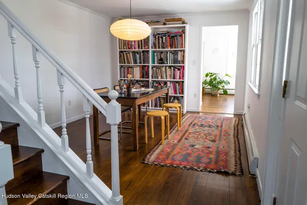 a view of a hallway with wooden floor and staircase