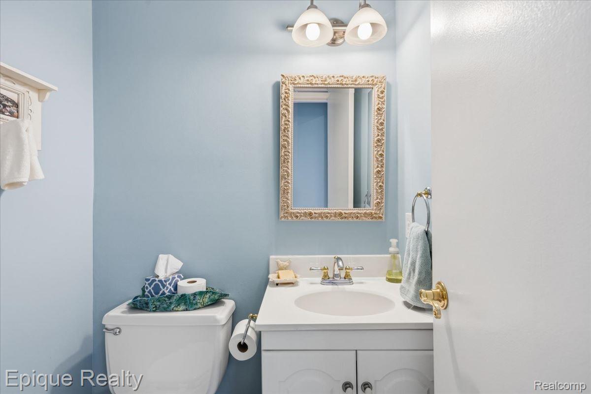 26 Kirks Court Rochester, MI 48309 - Photo 36 of 44 Bathroom featuring a white vanity with an integrated sink, gold-tone faucet, and a decorative framed mirror