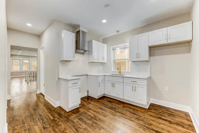 a kitchen with a sink cabinets stainless steel appliances and view living room