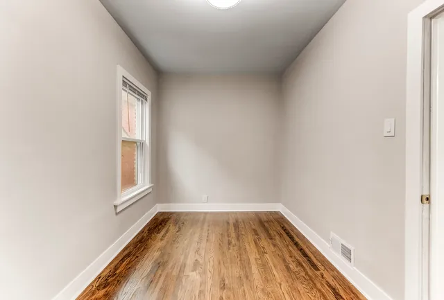a view of a room with wooden floor and window