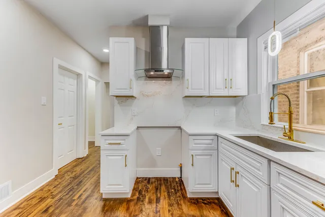 a kitchen with stainless steel appliances white cabinets and a stove top oven