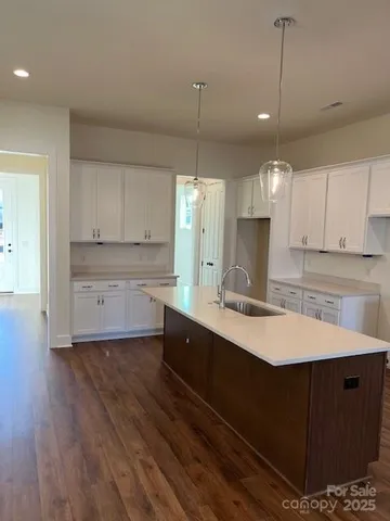 a large kitchen with kitchen island a sink stainless steel appliances and cabinets