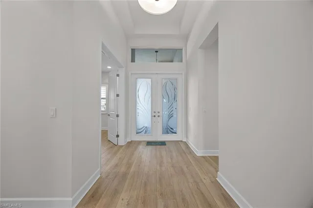 a view of a hallway with wooden floor and a bathroom
