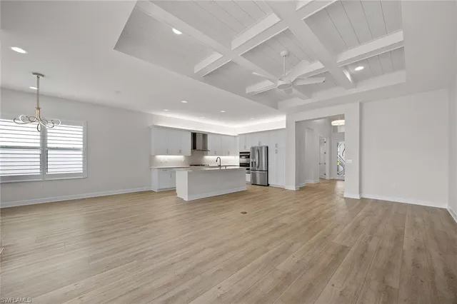 a view of kitchen with a sink wooden cabinets and window