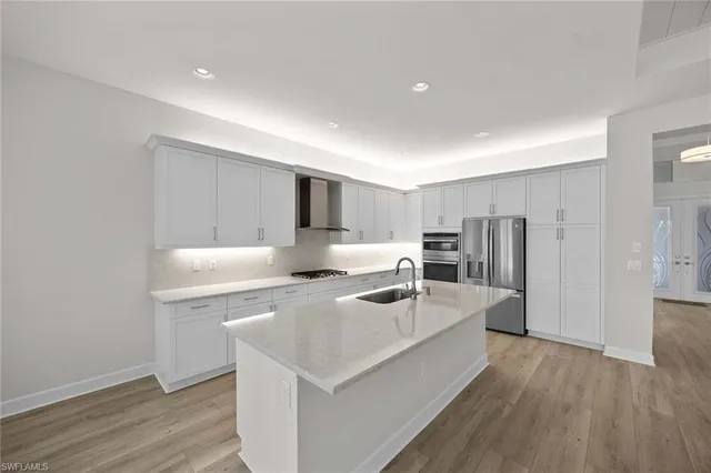 a kitchen with stainless steel appliances a sink a stove a refrigerator and cabinets