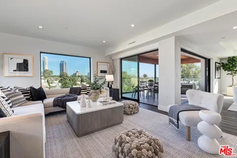 a kitchen with stainless steel appliances a dining table chairs and wooden floor