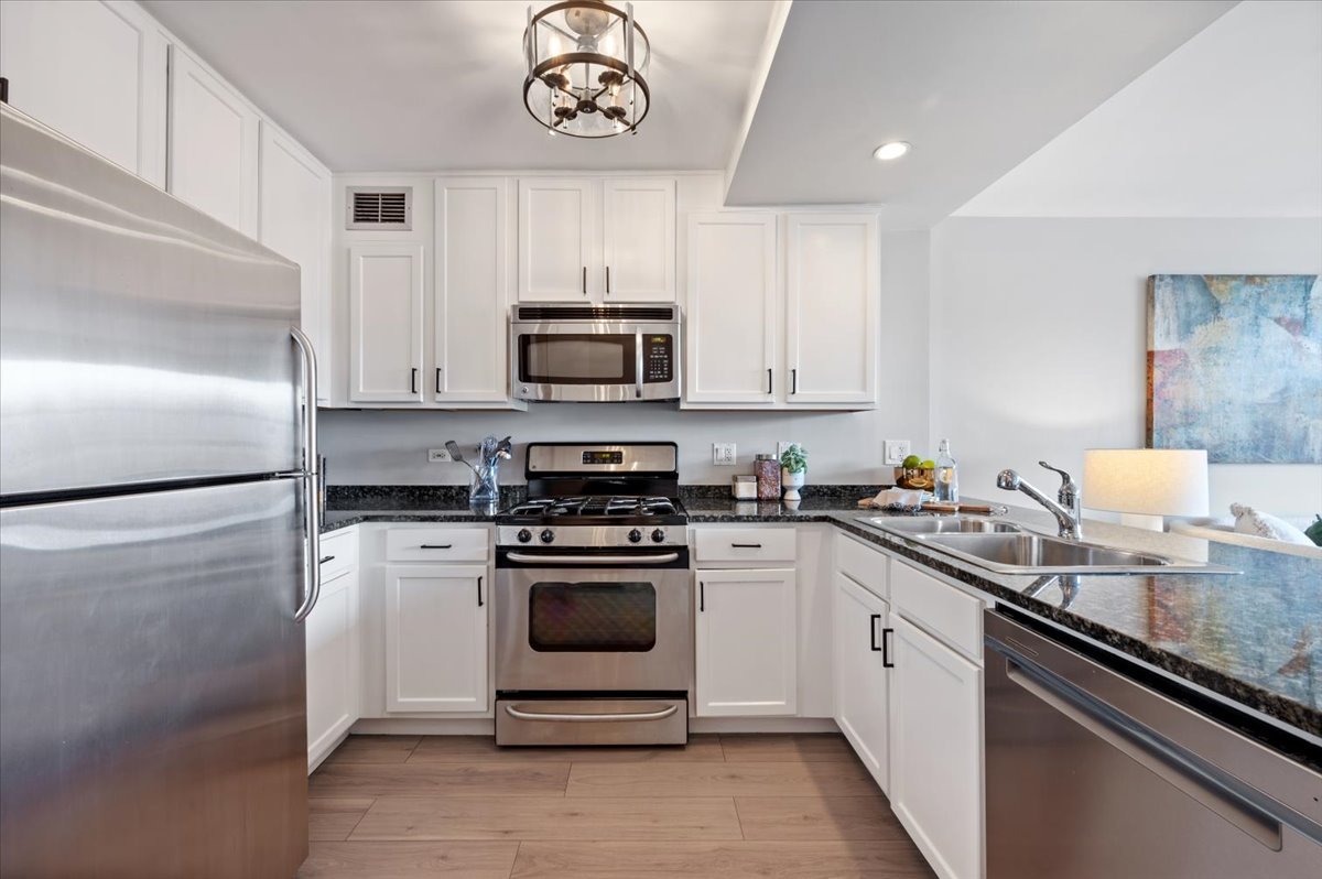 2300 North Commonwealth Avenue, Unit 7J Chicago, IL 60614 - Photo 11 of 20 a kitchen with a sink stainless steel appliances and white cabinets