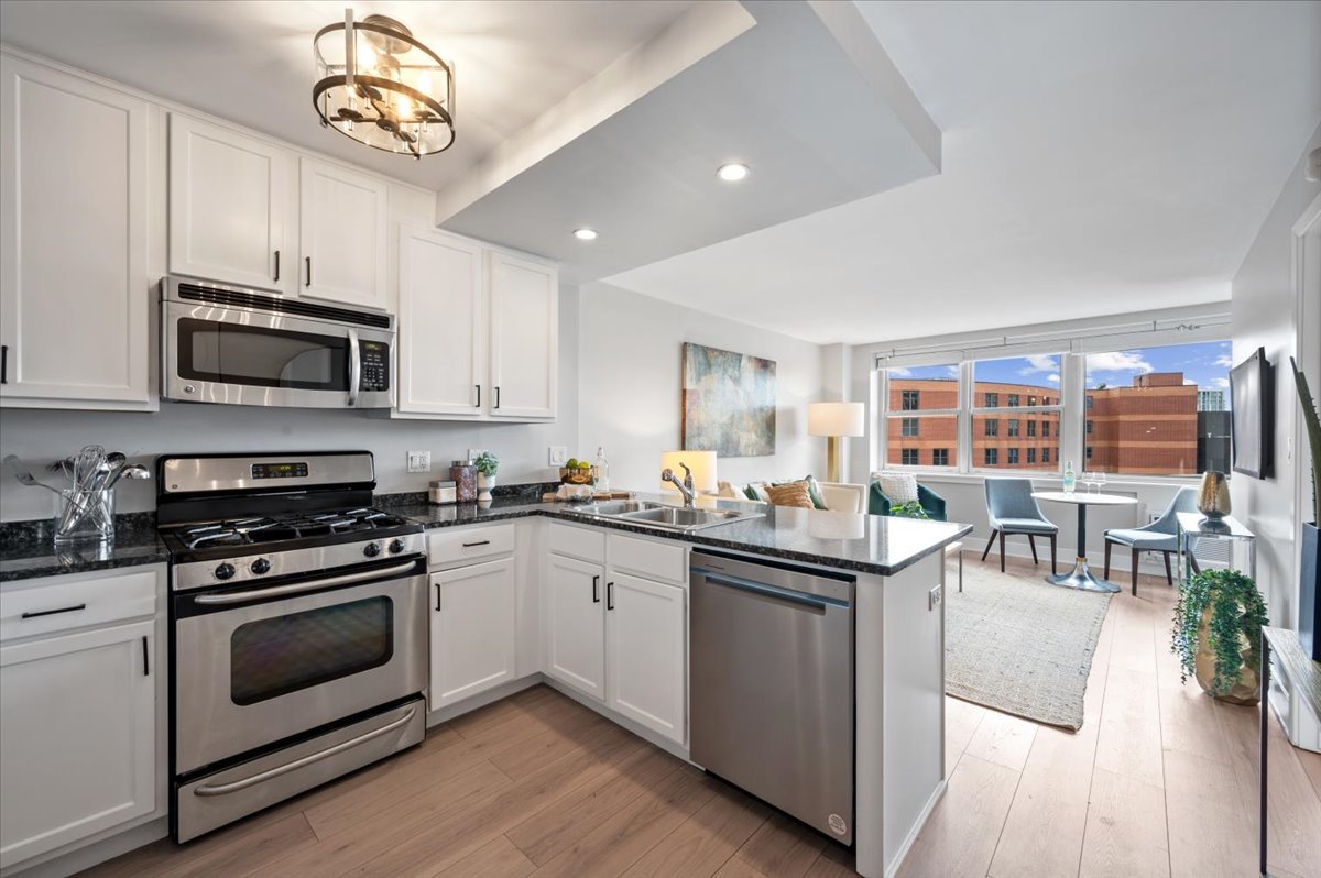 2300 North Commonwealth Avenue, Unit 7J Chicago, IL 60614 - Photo 12 of 20 a kitchen with stainless steel appliances granite countertop a stove top oven a sink dishwasher a dining table and chairs with wooden floor