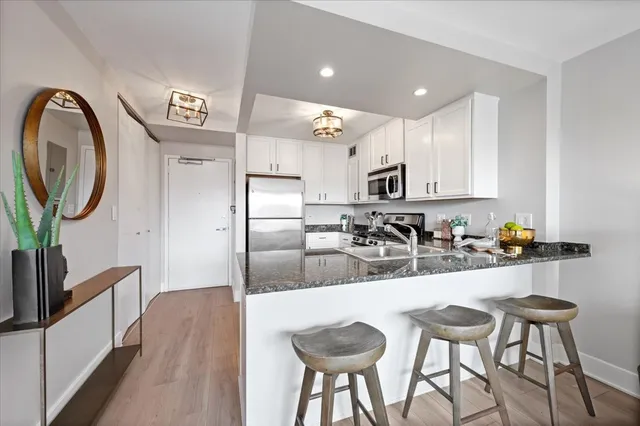 a kitchen with kitchen island granite countertop a sink and refrigerator