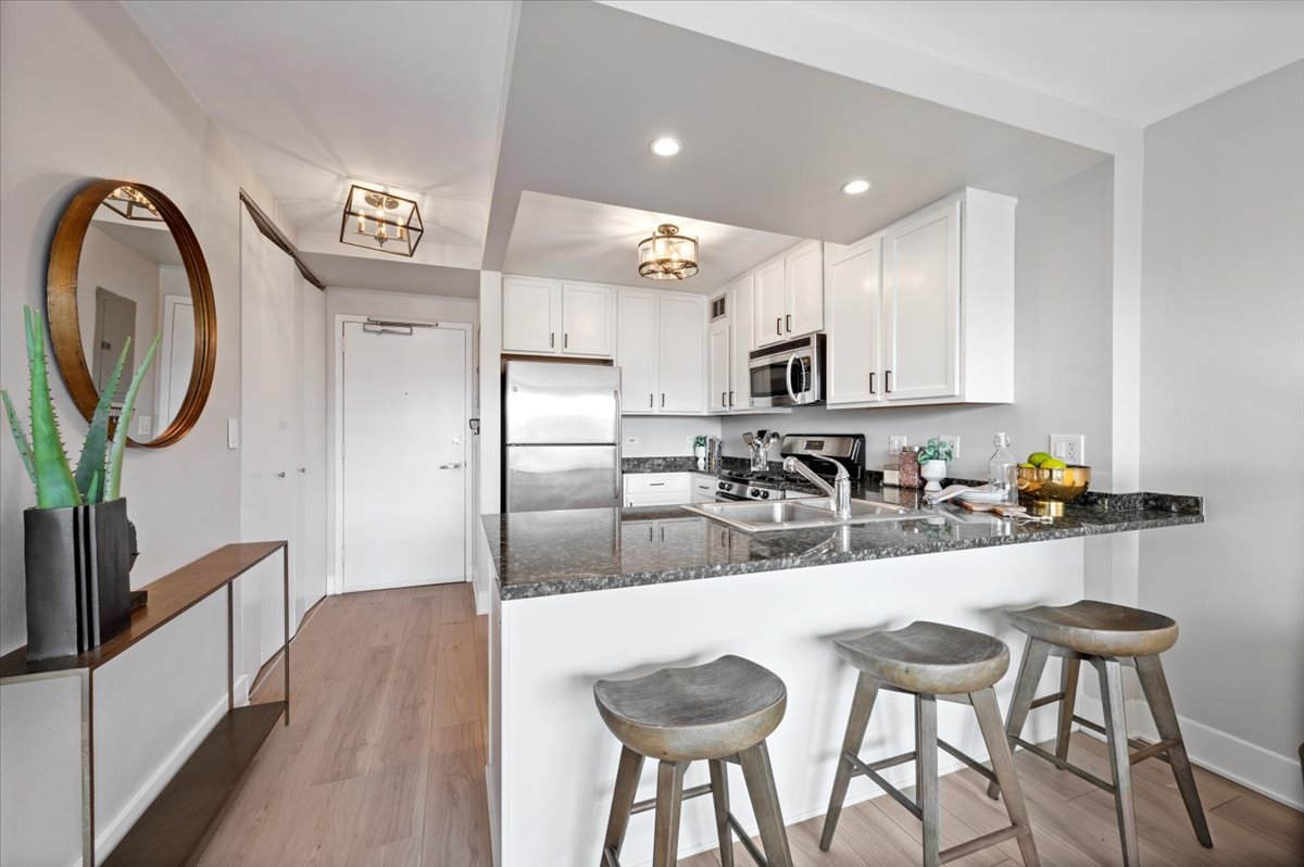 2300 North Commonwealth Avenue, Unit 7J Chicago, IL 60614 - Photo 10 of 20 a kitchen with kitchen island granite countertop a sink and refrigerator