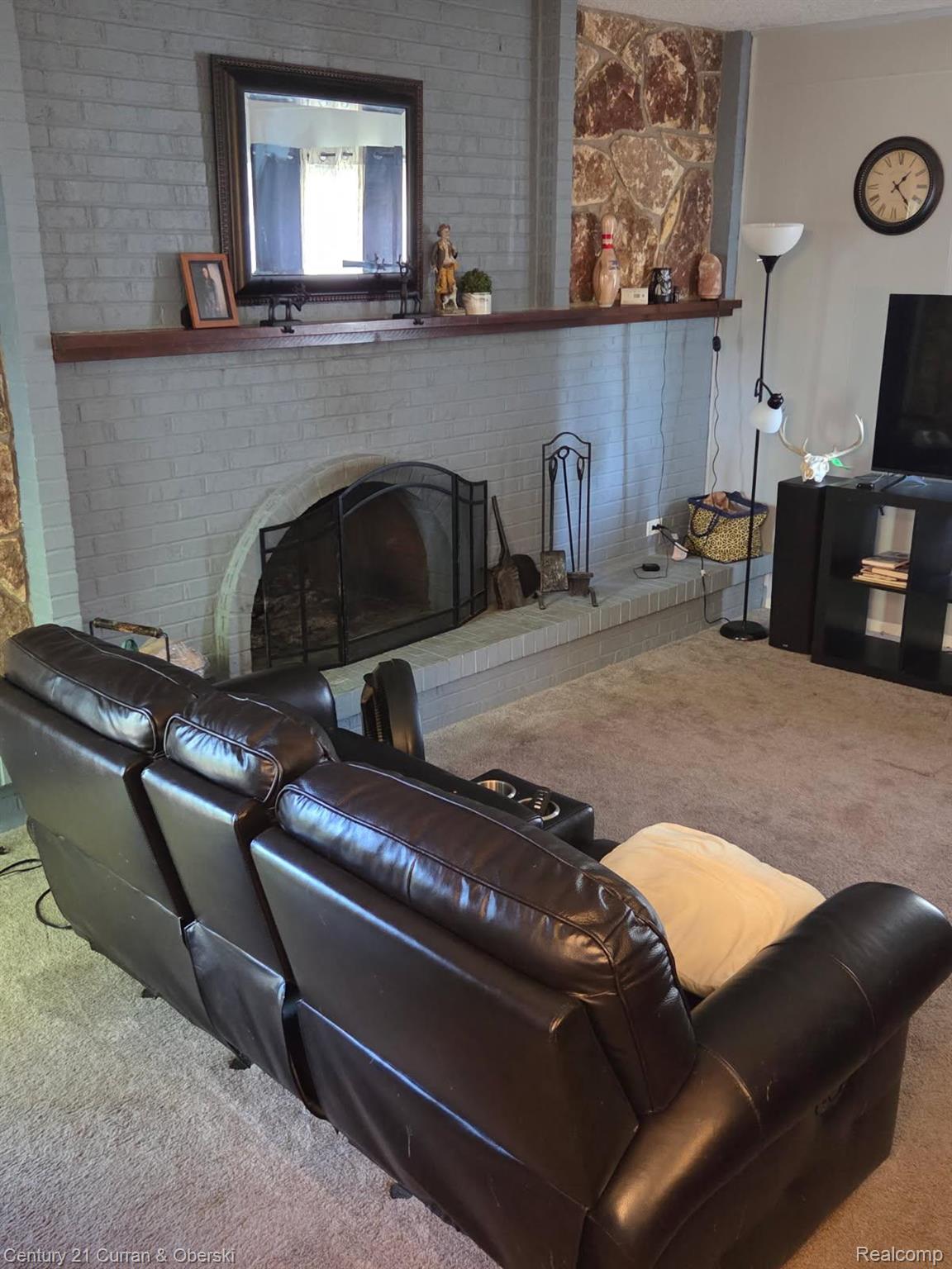 9371 Bennett Lake Road Fenton, MI 48430 - Photo 16 of 17 Fireplace featuring painted brick surround, natural stone accents, and a wood mantel